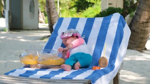 Cute Baby Girl Resting on Beach Chair in Tropics