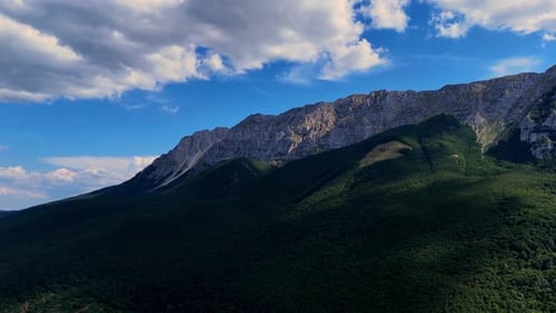 Majestic clouds gracefully drifting over a lush mountain range