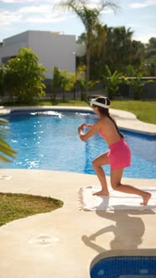 A Young Girl in a Virtual Reality Headset is Enjoying Outdoor Exercise By the Pool on a Sunny Day