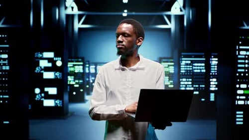 IT Specialist Walking Between Mainframes