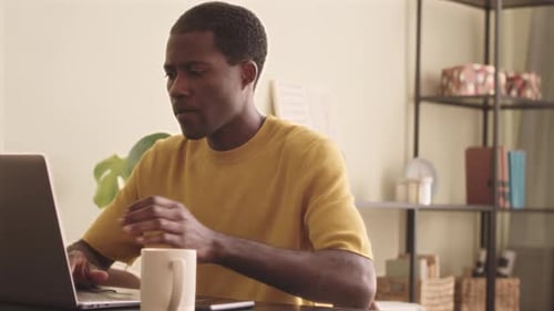 Young Adult Working from Home on Laptop