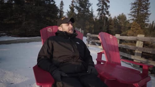 Un homme s'assoit sur une chaise rouge au point de vue de Hoodoos