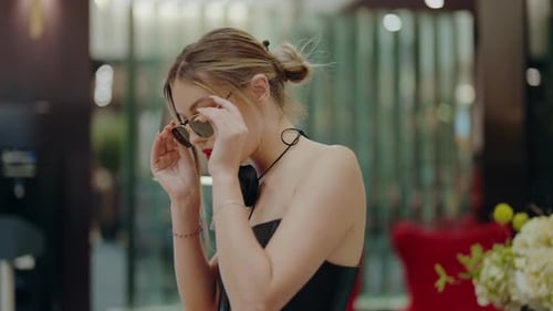 Woman Puts On Sunglasses Indoors