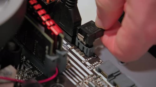 Hands Assemble Data Link to Mother Board in PC Close Up