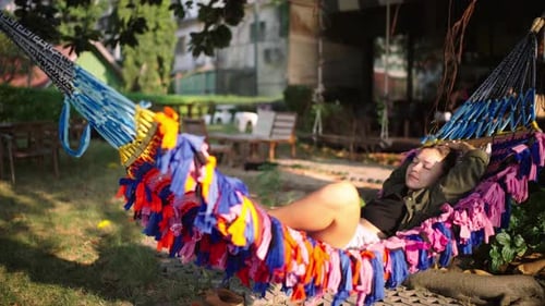 Young Woman Relaxing in Colorful Hammock