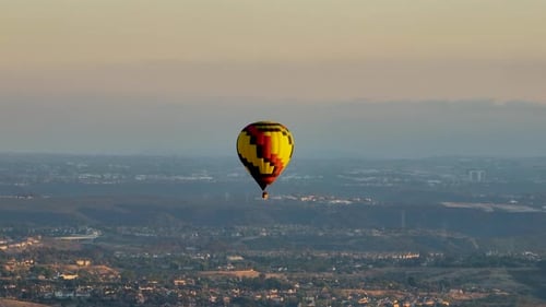 Hot Air Balloon Gliding Over Suburbs at Sunrise