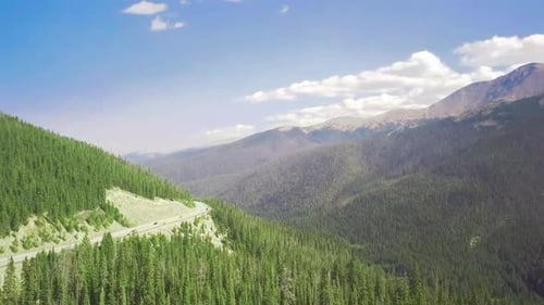 gorgeous mountain aerial overlooking a road and crisp pine trees