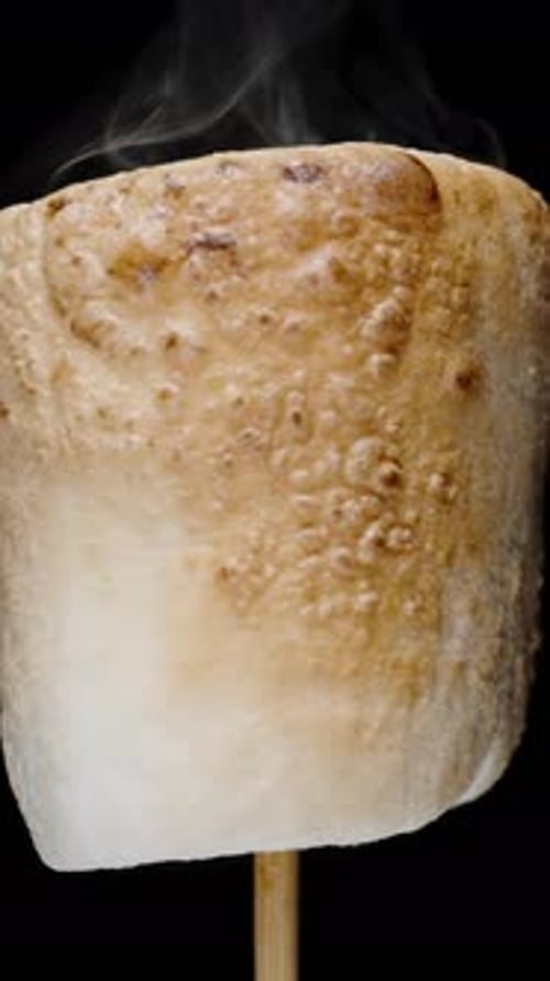Vertical video. Marshmallow Roasting on Stick, Bubbling and Expanding, Covered with Caramel Crust.