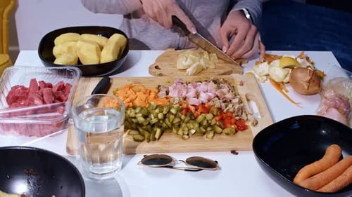 Static timelapse of woman slicing vegetables and meat for hearty homemade soup