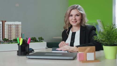 Real Estate Agent Closing Book at Desk in Office
