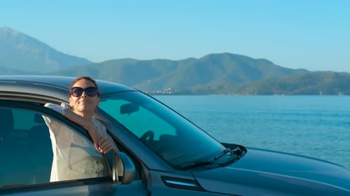 Woman Enjoying View From Car on Road Trip
