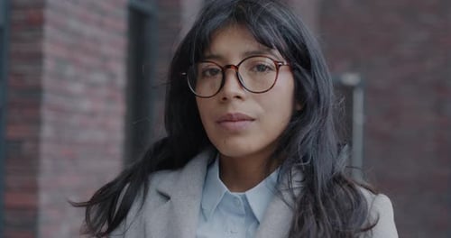 Closeup Slow Motion Portrait of Pensive Biracial Businesswoman Looking at Camera in Modern City