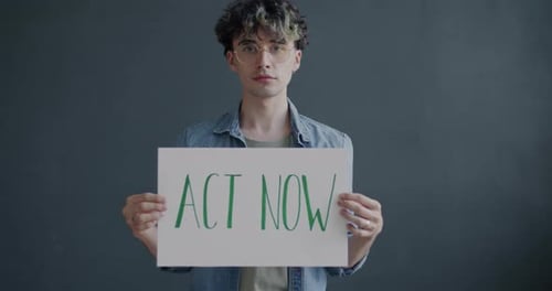 Person Holding Act Now Sign
