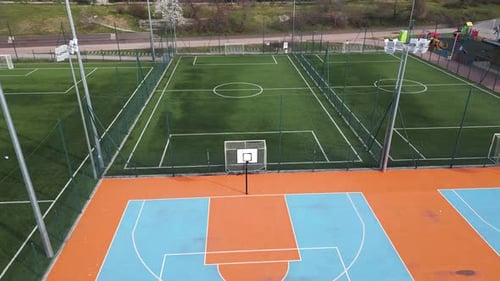 Aerial View of Outdoor Basketball and Soccer Courts with Vibrant Blue Orange and Green Colors The