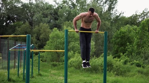 Strong and Muscular Man Doing Exercises on Horizontal Bar at Nature Hardy Shirtless Sportsman