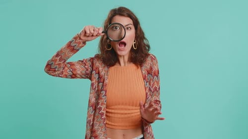 Chercheuse chercheuse femme avec une loupe près du visage regardant dans la caméra avec un gros œil