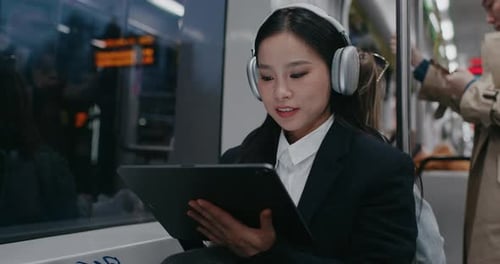 Young Woman Using Tablet on Public Transportation