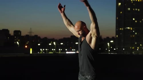 The Athlete Works Out the Muscles of the Arms and Back in the Light