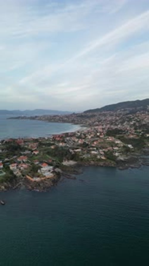Aerial view of coastal town with mountains and sea, Spain.