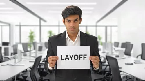 Angry Indian manager holding LAYOFF banner