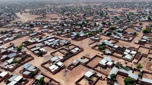 A suburb of Potiskum Town, Nigeria with home lots fenced off along dirt roads - ascending aerial vie