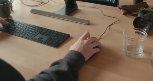 Mann arbeitet im Büro und klickt mit der Computermaus