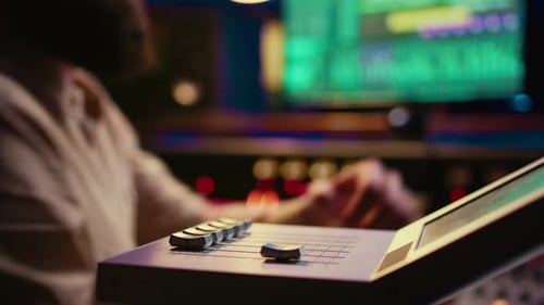 Sound Engineer Operating on Motorized Faders Controller in Professional Studio