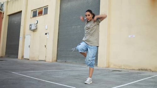 Young Woman Dancing Vigorously in Urban Setting