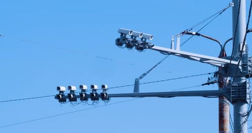 Security Cameras on Pole Against Clear Blue Sky