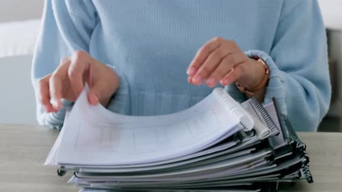 Accountant working with a stack of finance documents or books while audit data