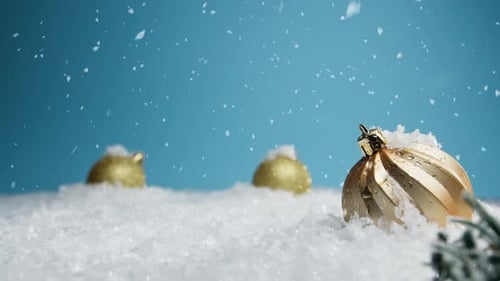 Gold Christmas Ornaments and Snowflakes Falling on Blue