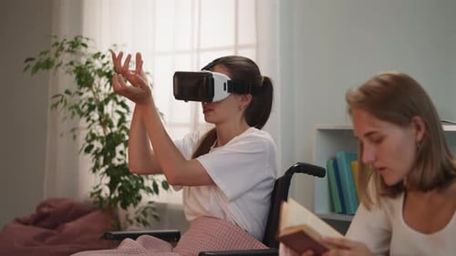 Behinderte Frau mit VR-Brille spielt Spiel, während Schwester liest