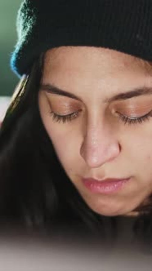Woman Looking Downward Wearing a Black Beanie