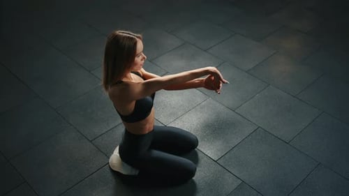 Athletic Young Woman in Black Sportswear Doing Stretching in Gym