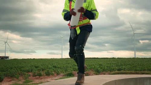 Smart engineer with protective helmet holding the blueprint working