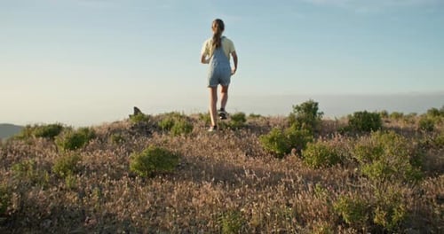 Slow Motion Video of a Girl Running to the Top of a Mountain