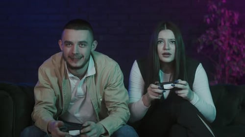 Young Adults Gaming at Home on Couch