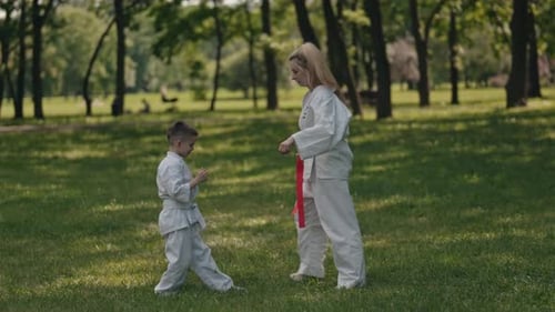 Karate Lesson in Park: Woman and Boy Practice Together