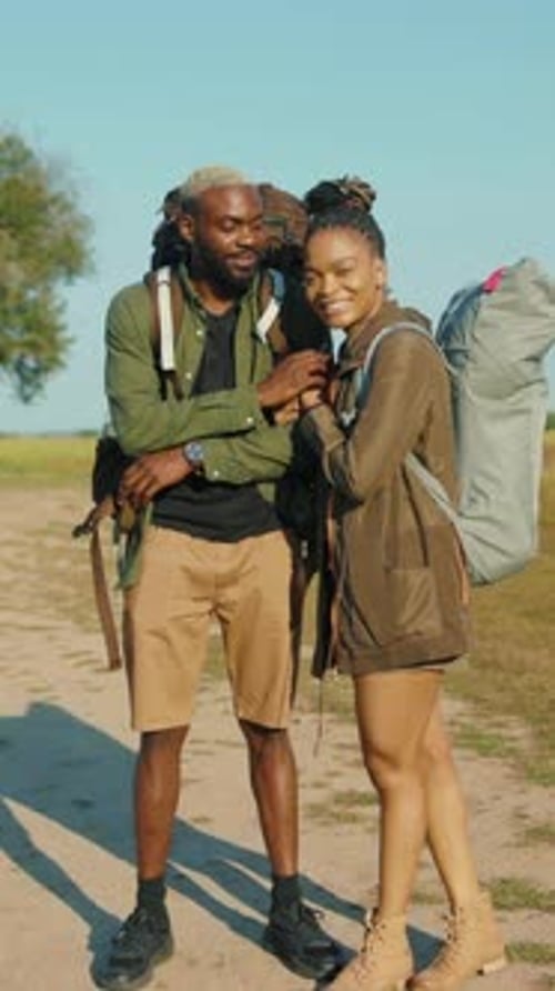 Young Couple Wearing Backpacks, Outdoor Setting