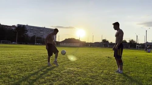 Two Sportsmen Showing Tricks with Ball While Passing It to Each Other at Field Young Men Kicking