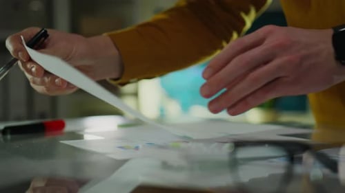 Hands Annotating Business Reports in Office Close Up