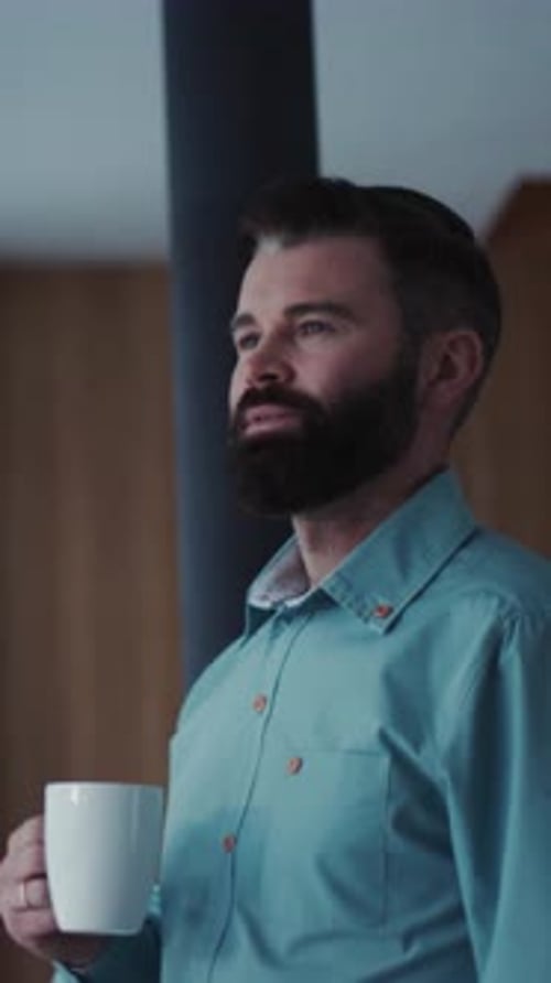 Man with Beard Drinks Coffee by Window