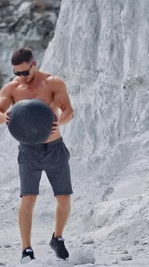 Fit Man Exercises with Medicine Ball in Quarry