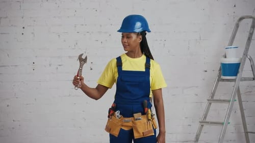 Medium Video of a Darkskinned Young Female Construction Worker Standing in the Room Wearing a Tool