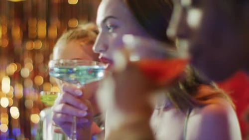 Video of caucasian woman drinking cocktail standing at a bar with diverse friends