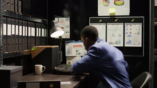 Man Working at Desk in Small File Room