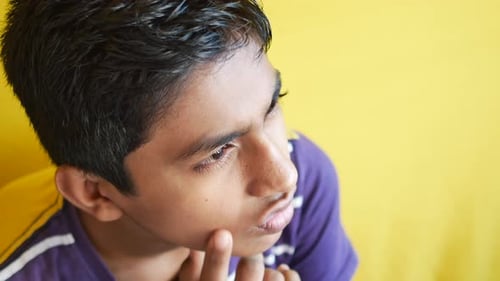 Thoughtful Boy Looking Away While Sited