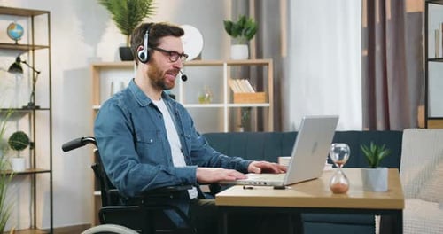Man in Wheelchair Using Laptop for Video Call