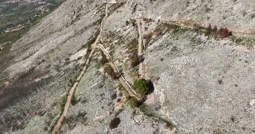 Paysage aérien, voiture traversant une colline de montagne, remontant la route, voyage sauvage et isolé, suivant un véhicule