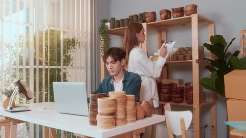 A young couple entrepreneur checking and packaging craft products selling